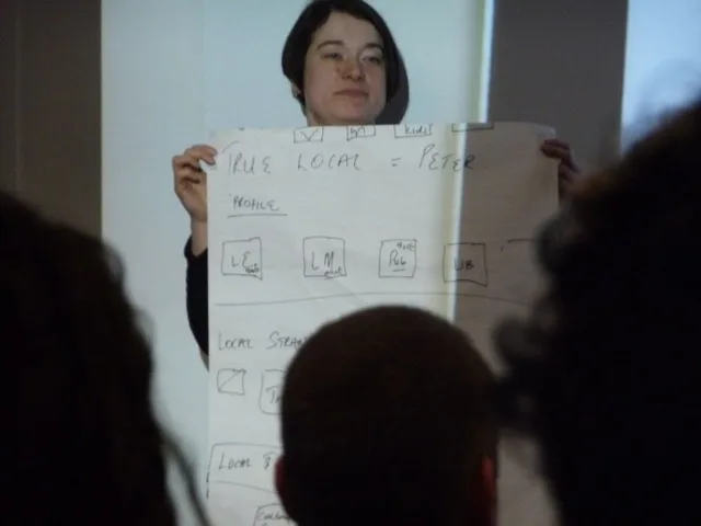 Tréner flipchartra jegyzeteli a workshop eredményeit a csoport előtt